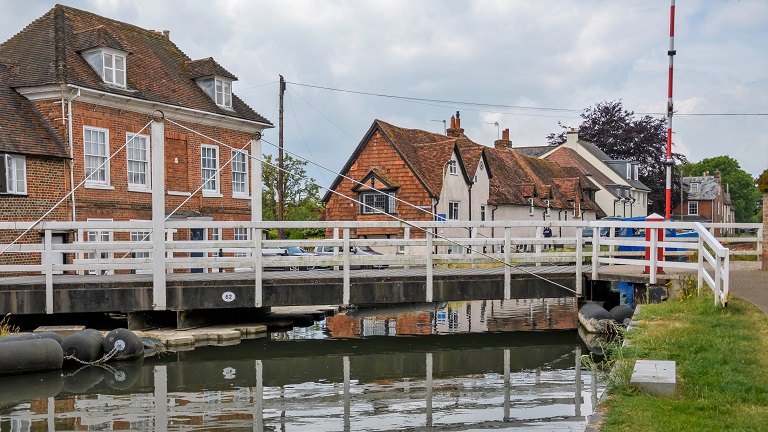 A bridge crossing over the Kennet and Avon Canal in Newbury with old houses in the background