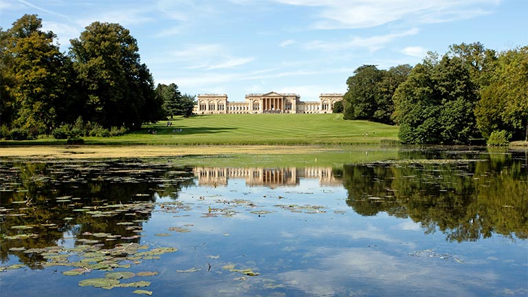 Looking across the lake and up the lawns at the historical Stowe House in Buckinghamshire
