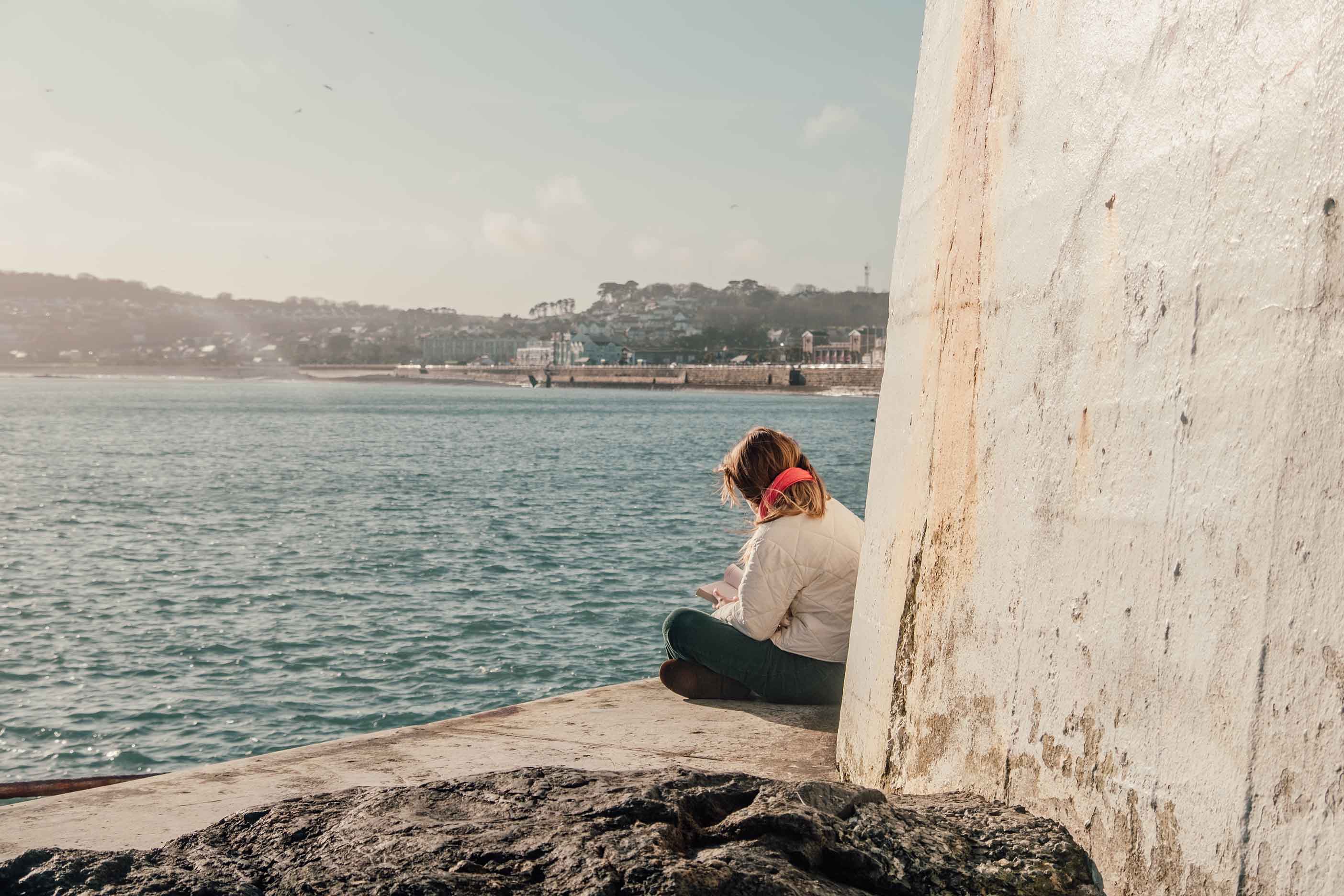 Girl reading at Battery Rocks Penzance