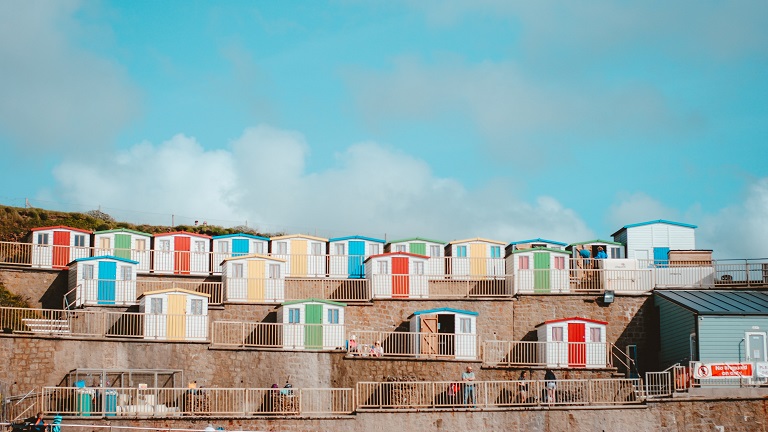 A view of Bude's colourful beach huts that sit above Bude Sea Pool on Summerleaze Beach