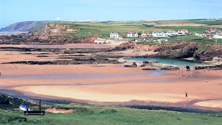 A long-distance shot of Bude's Summerleaze Beach with Bude sea pool in the distance