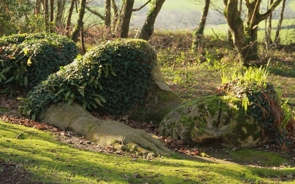 A sleepy statue within the wilderness at the Lost Gardens of Heligan, one of the many nature-inspired sculptures you can see