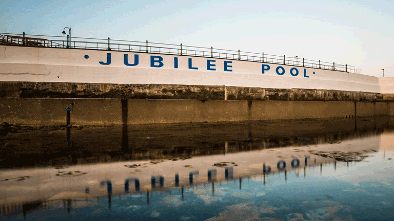 The Jubilee Pool sign reflected in the water