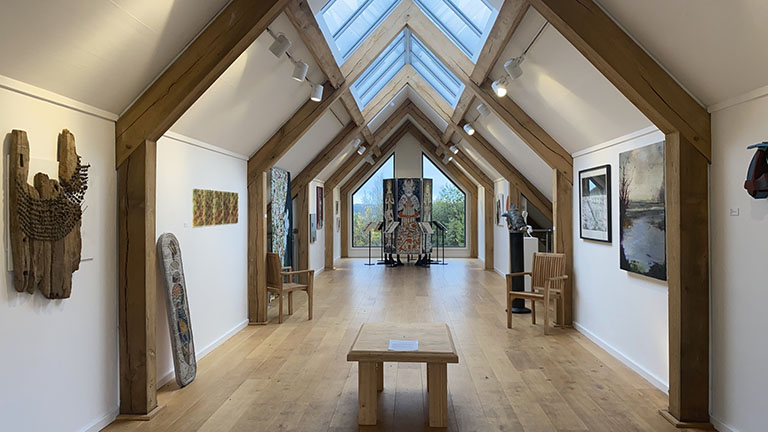 Inside the light-filled gallery at Tremenheere Sculpture Gardens with paintings and artworks on display