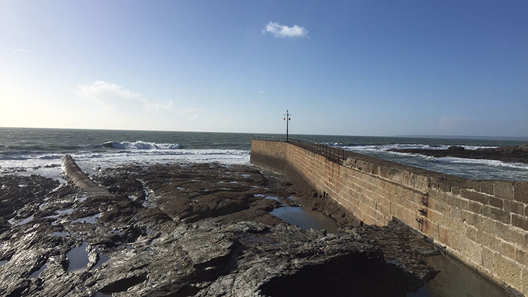 Porthleven's harbour wall extending out towards the sea