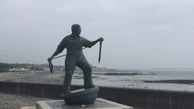 A bronze statue of a fisherman in Newlyn overlooking the sea