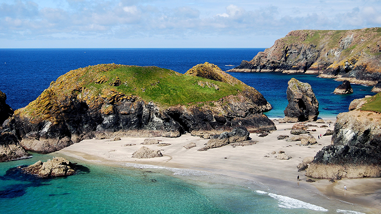 A view of the islands of Kynance Cove from the cliffs on the Lizard Peninsula in Cornwall on a sunny day
