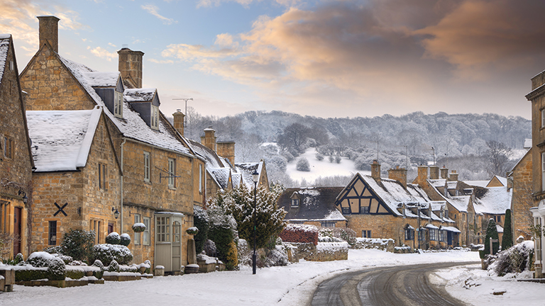 Snow over the main street and attractive historic buildings of Broadway in the Worcestershire Cotswolds