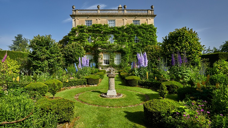 The beautiful gardens of Highgrove with a sundial in the middle and landscaped greenery