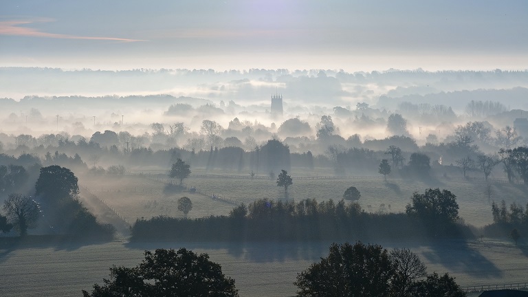 Beautiful Cotswolds countryside shrouded in mist 