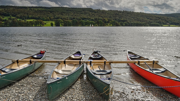 Boats on the shore of Coniston Water near Coniston Boating Centre, one of the best family-friendly visitor centres in the Lake District.