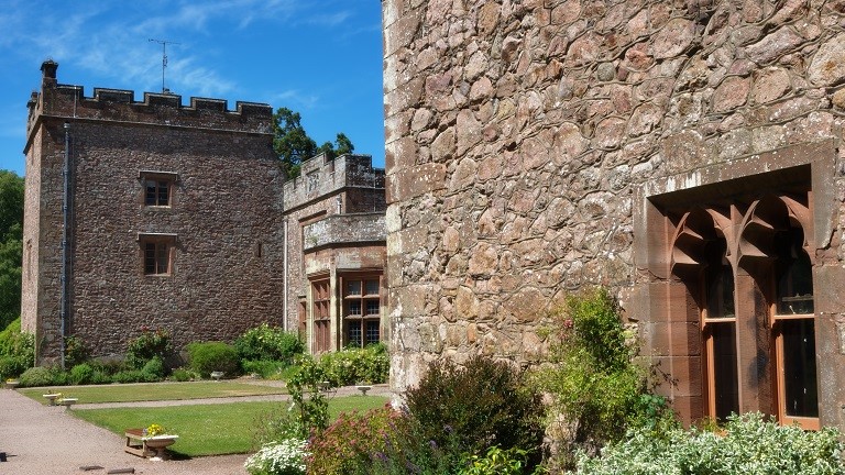 Outside the walls of Muncaster Castle near Ravenglass in the Lake District, with manicured lawns and pruned shrubs 