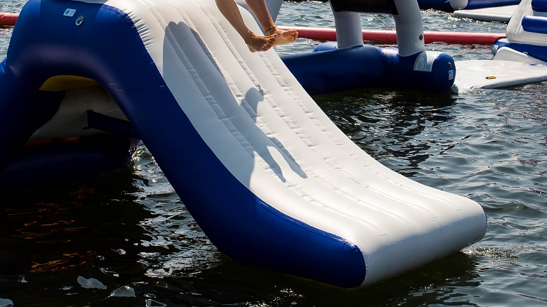An inflatable waterslide within a lake aqua park, great fun for all the family