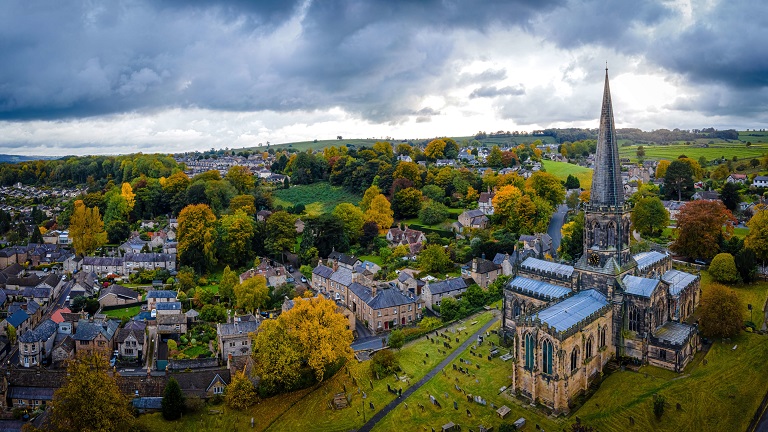 Overlooking the town of Bakewell, with All Saints Church in the foreground and the town's houses and buildings in the background, surrounded by greenery