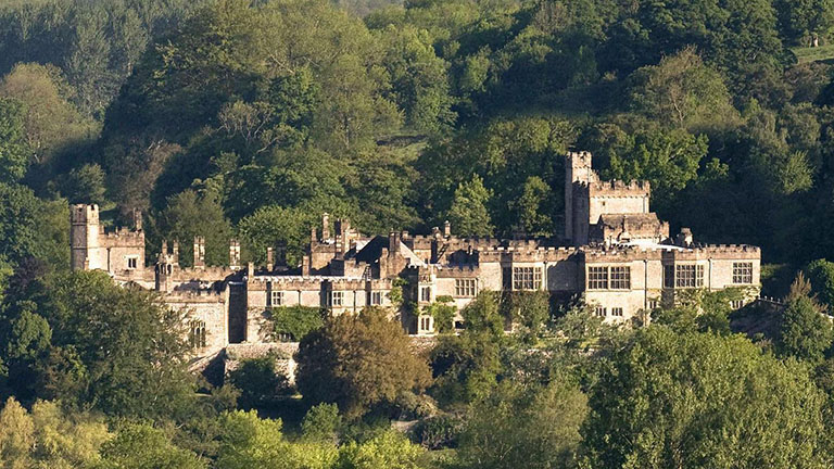 A view of Haddon Hall through the trees 
