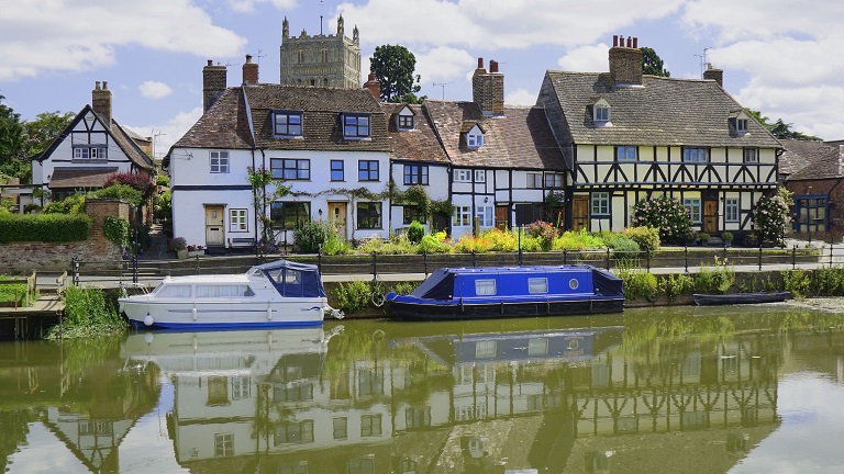 A view of Tewkesbury over the water with traditional houses 
