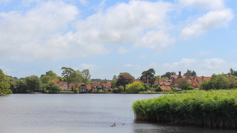 A view over a lake of Beaulieu village in the New Forest, Hampshire, with period houses in the background