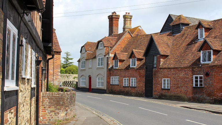 A street in Beaulieu in the New Forest, Hampshire, lined with red brick and historic houses