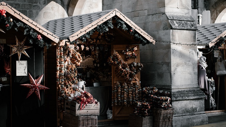 Christmas market stands and wooden huts decorated with ornaments at Winchester Cathedral Christmas Market