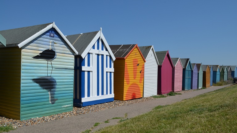 Brightly coloured and decorated beach huts on Herne Beach in Kent