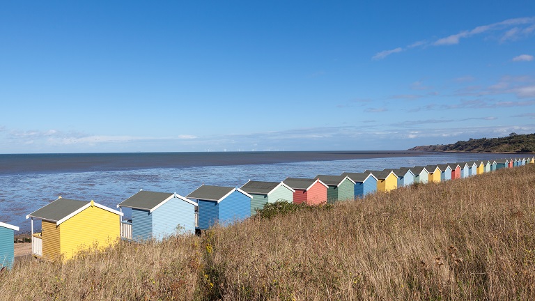 Sheerness Beach's multi-coloured beach huts lining the promenade and overlooking the sea