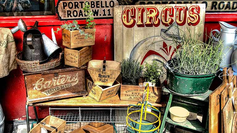 A collection of vintage signs and items at a stall at Portobello Road Market in London