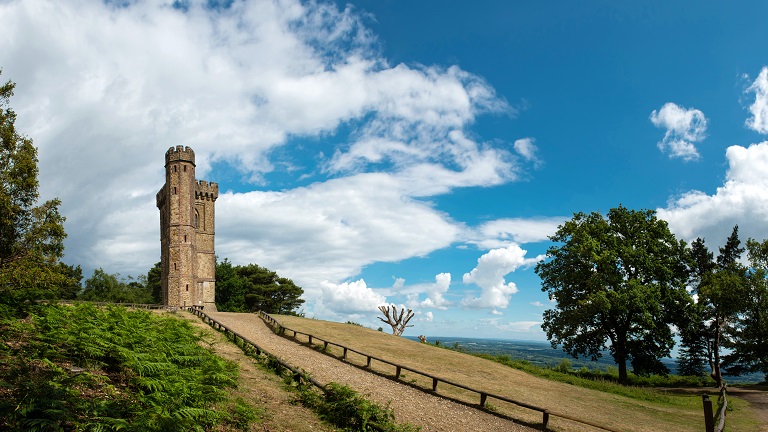 Leith Hill Tower from below with blue sky and clouds overhead