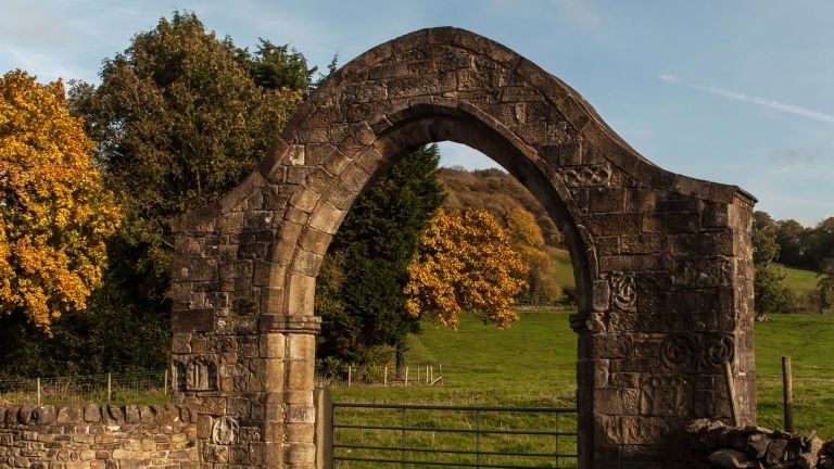 An ancient arch bathed in golden light at Sawley Abbey