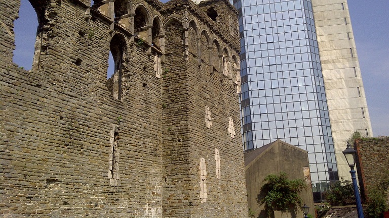 A view of the remains of the 12th Century Swansea Castle with modern high-rises in the background