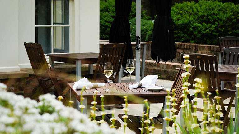 The outdoor garden with tables and chairs at Arras restaurant in York
