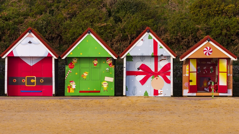 Christmas themed beach huts lining the beachfront in Bournemouth
