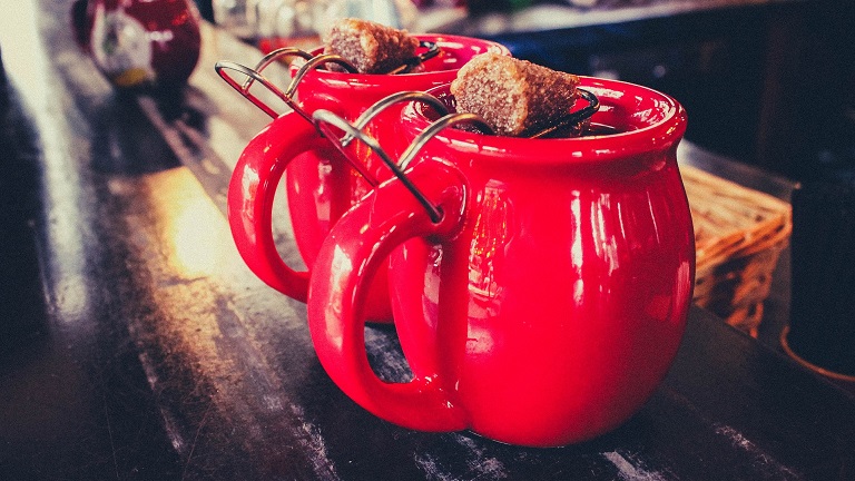 Mugs of mulled wine topped with brown sugar cubes