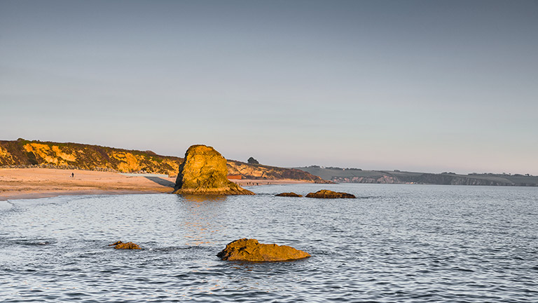Golden hour over Carylon Bay in South Cornwall, one of the longest beaches in Cornwall