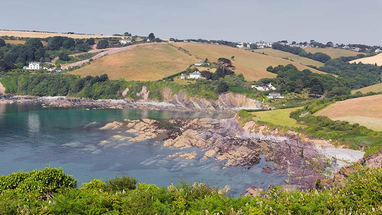 Rolling countryside sits above the rocky coves around Talland Bay in Cornwall