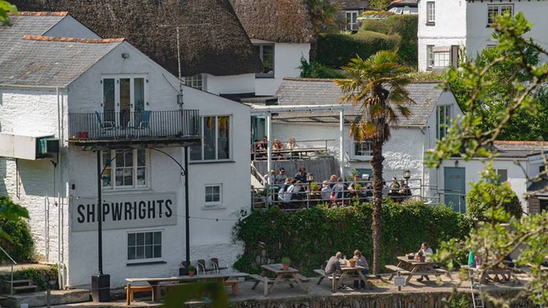 The white-washed facade of the Shipwright Arms pub in the Helford