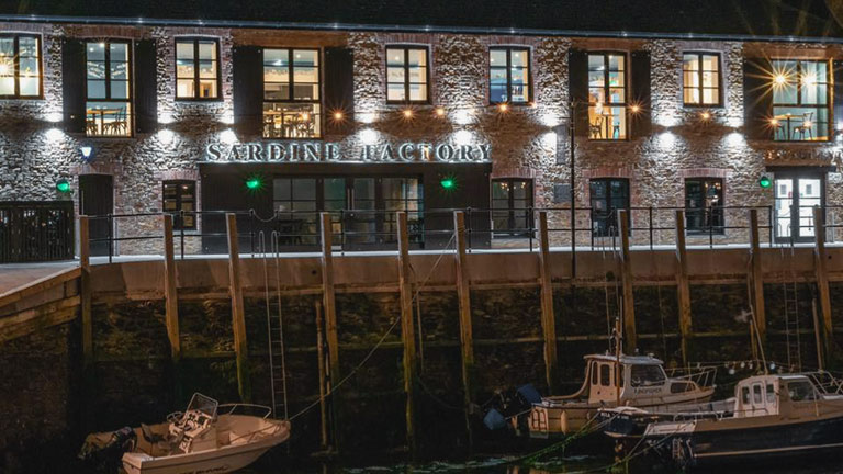 The spotlit facade of the Sardine Factory restaurant in Looe