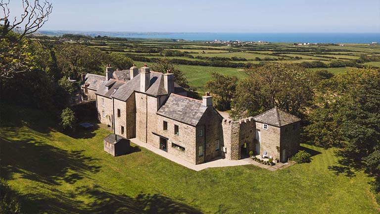 A beautiful honey-bricked stately home overlooking fields and the sea