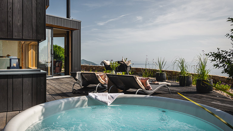 The ocean-view hot tub and deck of Fika, Whitsand Bay | Boutique Retreats