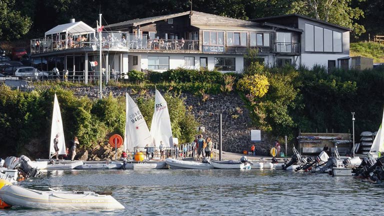 A view of Helford River Sailing Club from the water and pontoons