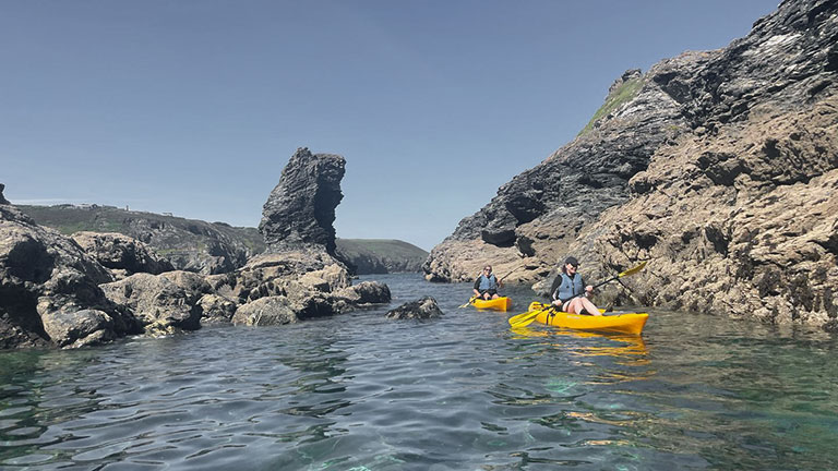 Kayakers exploring the St Agnes coastline with Koru Kayaking on a sunny day