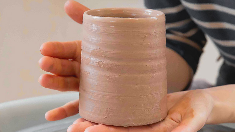 Someone making a clay vase at Bernard Leach Pottery School