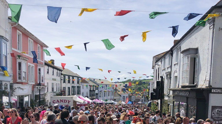 Bunting lining the streets and crowds gathering for Helston's annual Flora Day festivities in May