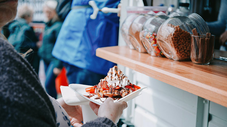 A waffle topped with strawberries, cream and drizzled chocolate at Porthleven Food Festival