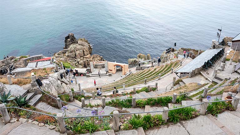 Looking down the grassy steps at the Minack Theatre with the sea beyond