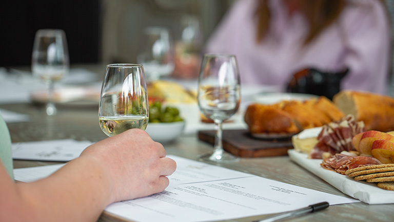 A glass of white wine on the table during a tasting experience with Cornish Wine Tasting at The Granary on the Roseland 