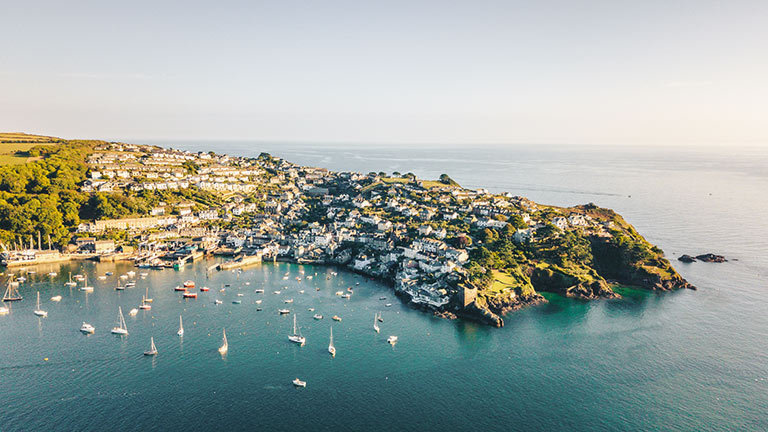 An aerial view of the harbourside town of Fowey in South Cornwall under golden sunshine