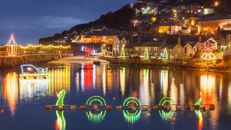 Beautiful Christmas lights illuminating the harbour and oceanfront streets of Mousehole in West Cornwall at night