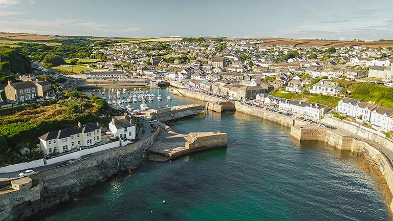 An aerial view of Porthleven town and harbour on a blue sky day