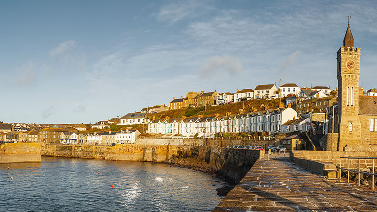 A view of Porthleven's clocktower and cottages at golden hour