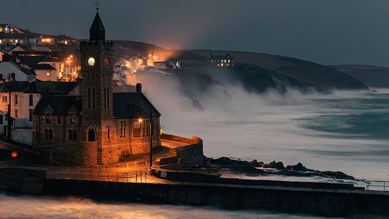 Waves crashing against the cliffs and sea walls during a storm in Porthleven 